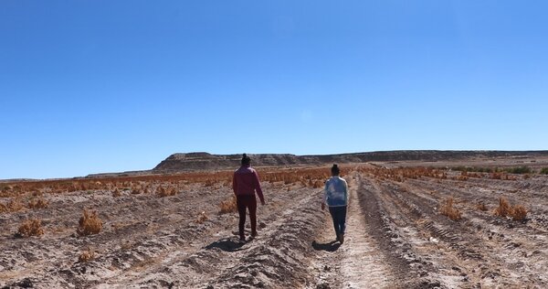 women walking through barren field